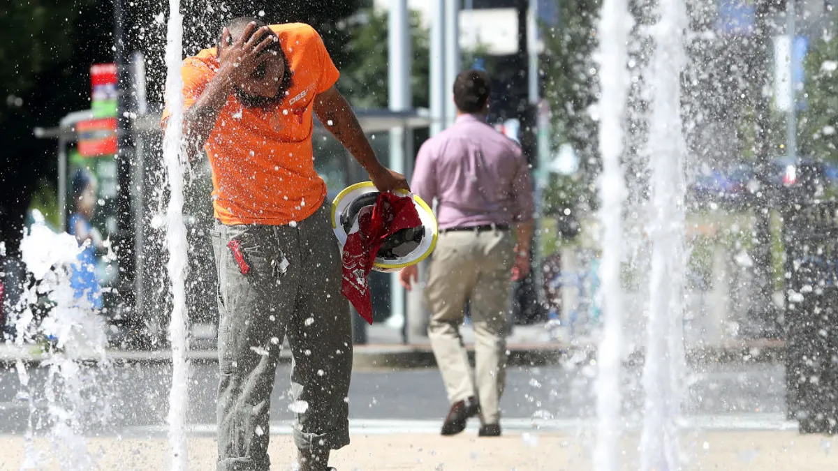 I lavoratori edili utilizzano la fontana d'acqua durante la giornata calda